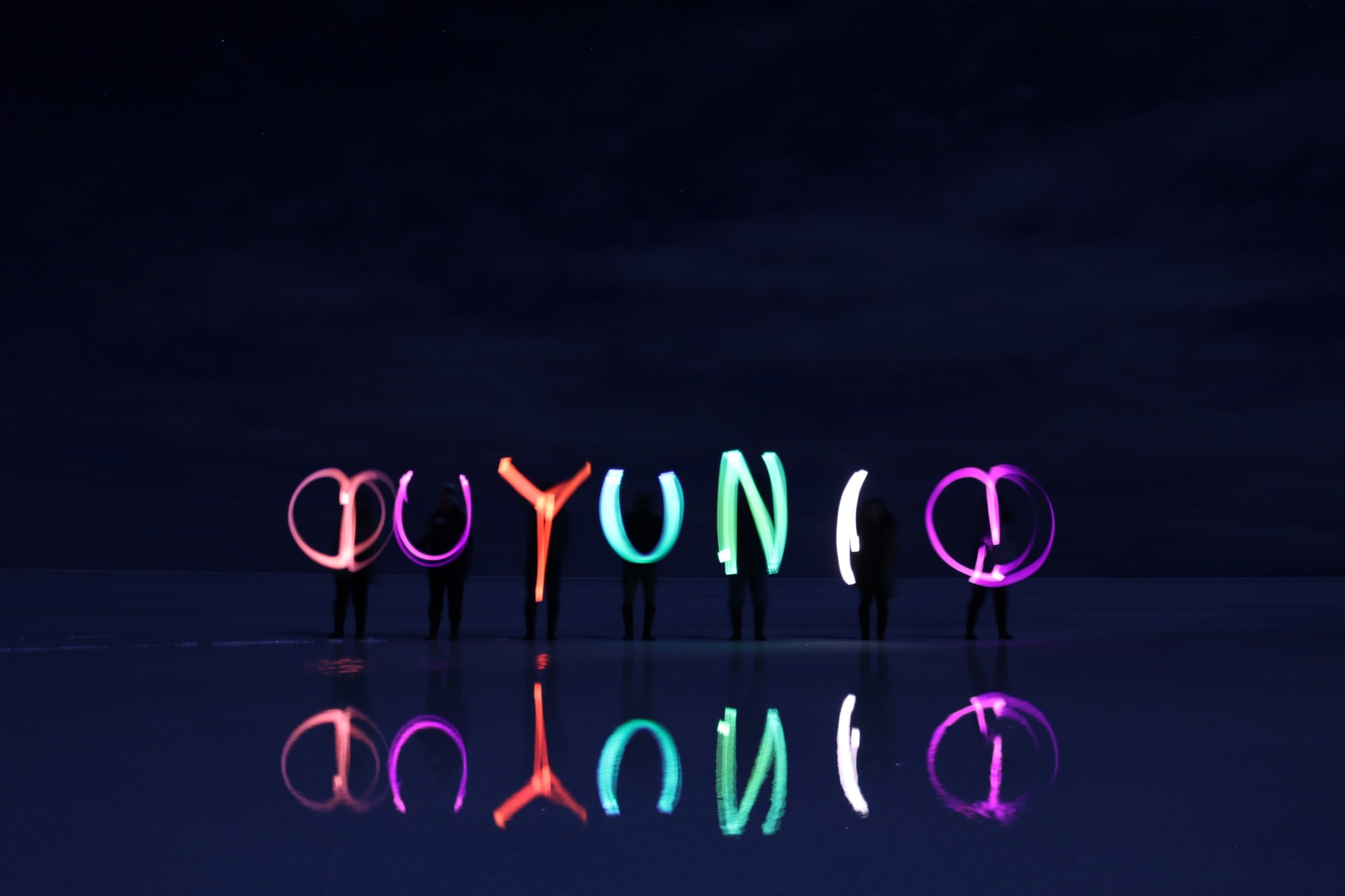 光の軌跡で描いた「UYUNI」の文字が水面に映る写真